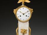 a gold and white clock with a bird on top of it