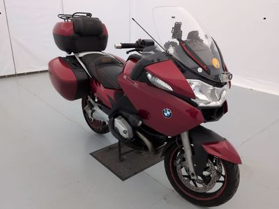 une moto rouge garée dans une pièce aux murs blancs