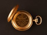 a gold pocket watch on a black surface