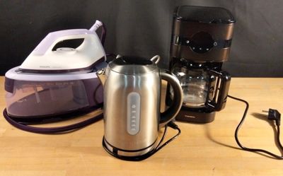 trois types différents de cafetières posées sur une table en bois