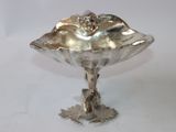 a silver plate with a bird on it on a table