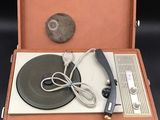 an old record player in a case with a remote
