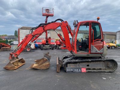 a red excavator that is sitting in a parking lot