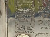 une boîte en argent sur laquelle se trouve une pièce de monnaie