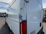 the back end of a white van parked in a parking lot
