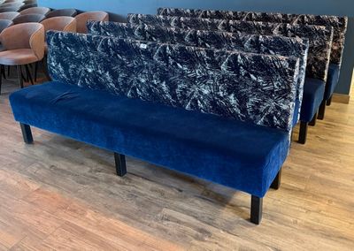 un banc bleu dans une pièce où se trouvent des chaises