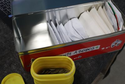une boîte remplie de papiers, avec un récipient jaune à côté