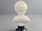 a close up of a white bust of a woman on a black base