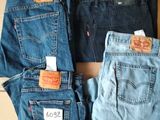 Trois paires de jeans Levi's sont posées sur une boîte en carton