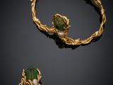 a gold bracelet and ring with a green beetle on it