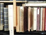 many old books in a black case on the shelf