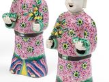 three ceramic figurines of a man and a woman holding flowers