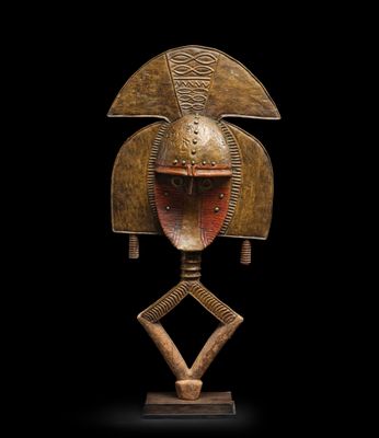 une image représentant un masque en bronze sur fond noir