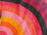 a close up of a pink, orange and black scarf with a rainbow design