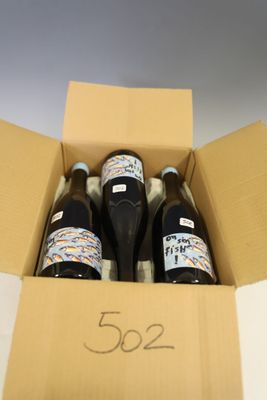 three bottles of wine in a box on a table