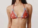 La femme porte un bikini rouge et bleu orné d'étoiles blanches.