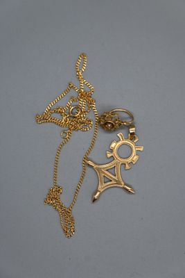 Gros plan sur un collier en or orné d'une croix