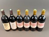 six bottles of wine are lined up in a row on a table