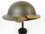 an old army helmet with a cloth band on a stand