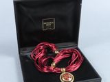 une photo d'un collier et d'un bracelet rouges dans un coffret noir