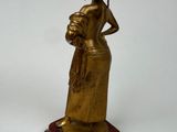 brass figurine of a woman holding a basket of flowers on a marble base