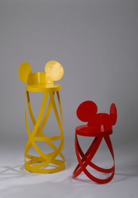 une chaise Mickey Mouse jaune et rouge à côté d'une chaise Mickey Mouse rouge
