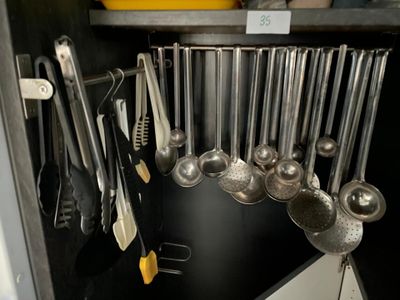 un gros plan sur un ensemble d'ustensiles de cuisine rangés dans un placard