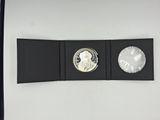 a close up of a coin in a black box on a white surface