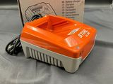 a close up of an orange and white battery charger on a table