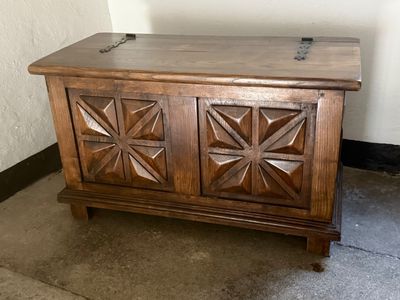 a wooden chest sitting on the floor in the corner of a room
