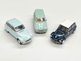 trois petites voitures miniatures sont posées les unes à côté des autres sur une surface blanche