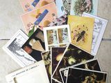 a pile of postcards sitting on the floor next to a pair of scissors