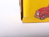 a red toy truck in a yellow box on a table