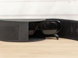 a pair of sunglasses in a black case on a wooden table