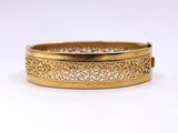 a close up of a gold bracelet on a white background