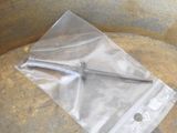 a plastic bag with a hammer in it sitting on the ground