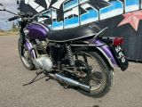 a purple motorcycle parked in front of a graffiti covered wall