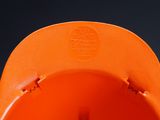 a close up of an orange hat on a black background