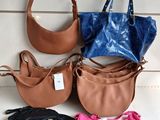 four different purses are lined up on a white surface