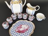 une image représentant une table avec une assiette, des tasses et une théière