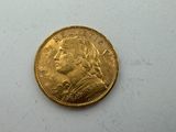 a gold coin on a white surface