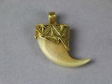 an image of a gold pendant with an elephant ' s tusk on it