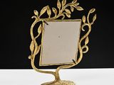 brass frame with a leaf design on a stand