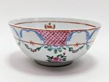 un bol blanc orné d'un motif rouge et bleu