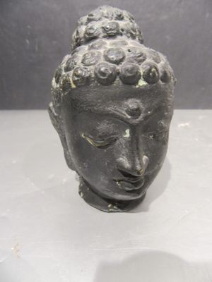 a small statue of a head on a table