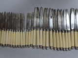 six fourchettes et un couteau sont alignés sur une table