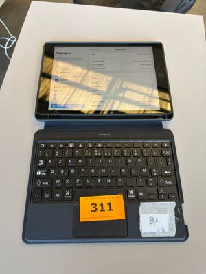 a laptop computer sitting on top of a table with a sticker on the keyboard