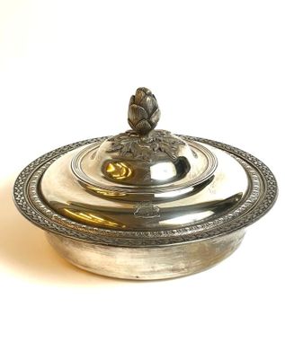 a silver plate with a bird on top of it