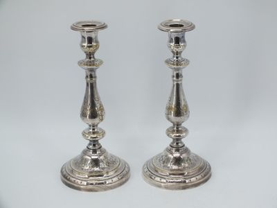 pair of silver candlesticks on a white background