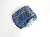 blue ceramic square dish with a decorative design on it